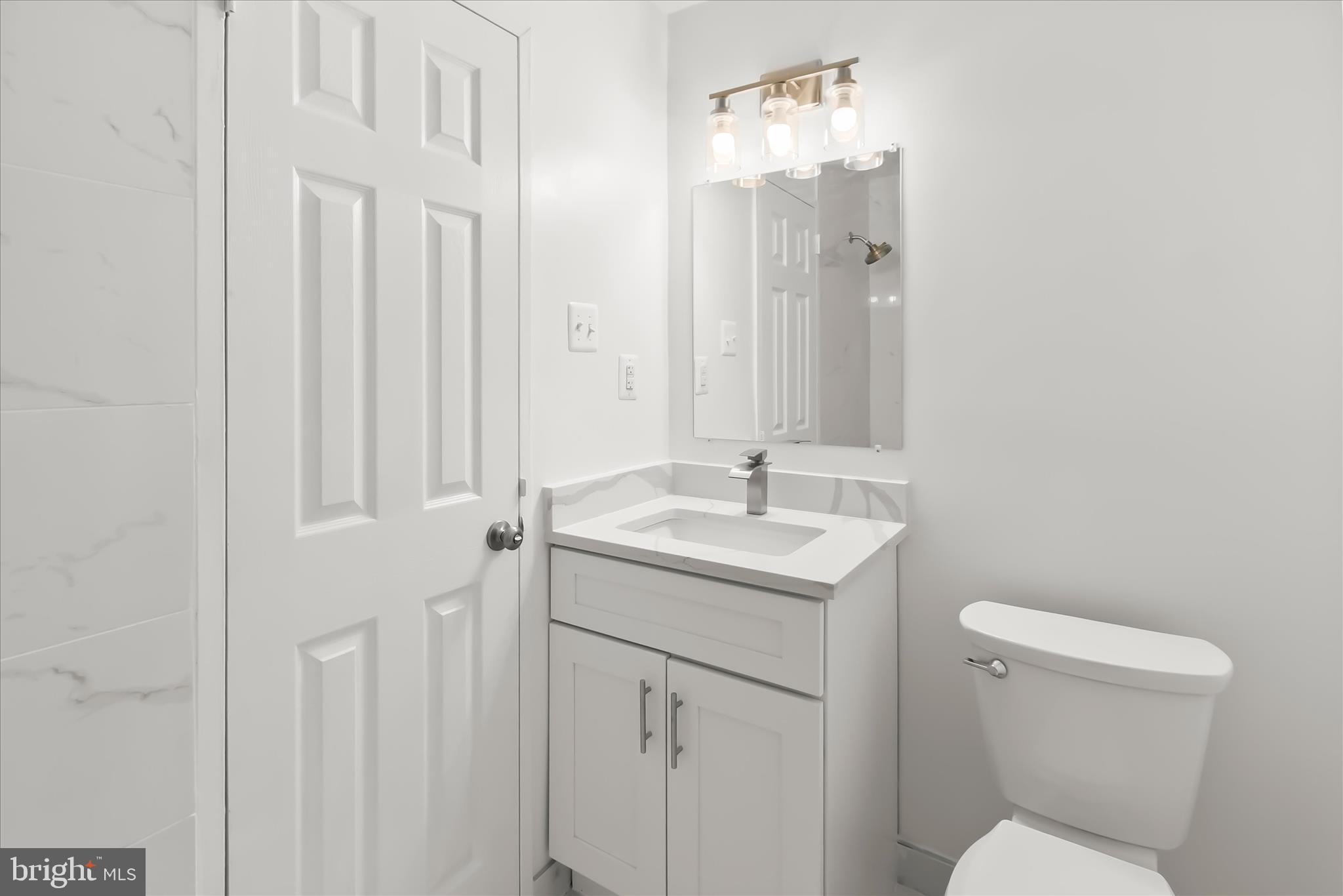 1900 Lyttonsville Road, Unit 216 Silver Spring, MD 20910 - Photo 19 of 36 a bathroom with a toilet a sink and mirror
