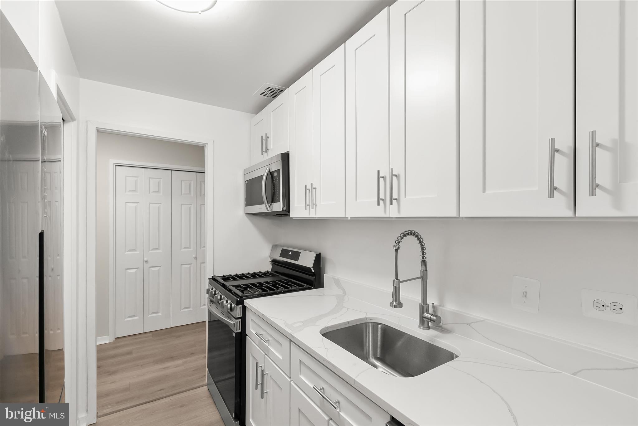 1900 Lyttonsville Road, Unit 216 Silver Spring, MD 20910 - Photo 2 of 36 a kitchen with stainless steel appliances granite countertop white cabinets a sink and dishwasher
