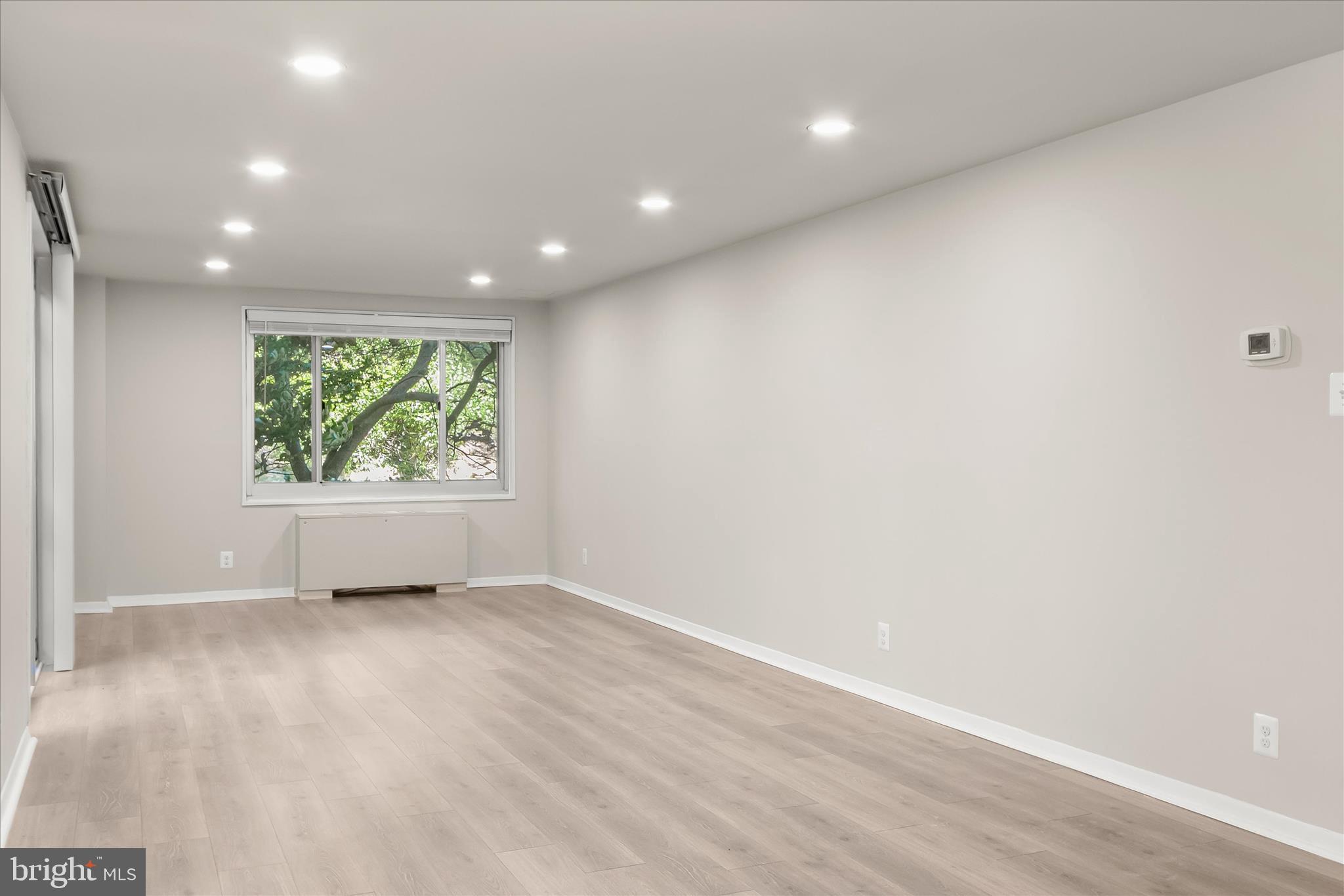 1900 Lyttonsville Road, Unit 216 Silver Spring, MD 20910 - Photo 6 of 36 an empty room with wooden floor and windows