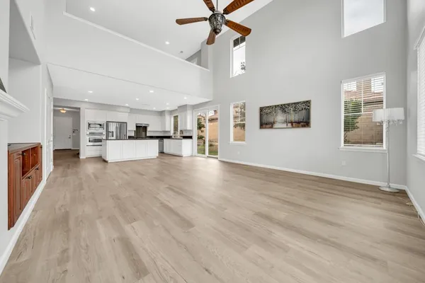 a large kitchen with stainless steel appliances granite countertop a large counter top and a stove top oven with wooden floor