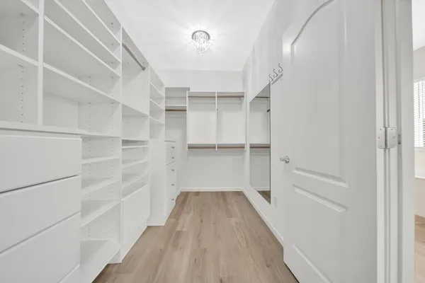 an empty room with windows and ceiling fan