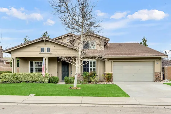 a front view of a house with a garden and garage