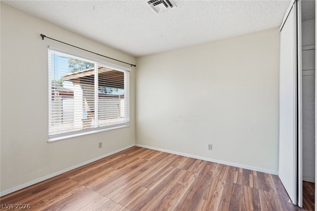 3971 Spring Leaf Drive Las Vegas, NV 89147 - Photo 15 of 48 A quiet bedroom featuring rich wood flooring and a wide window with blinds.