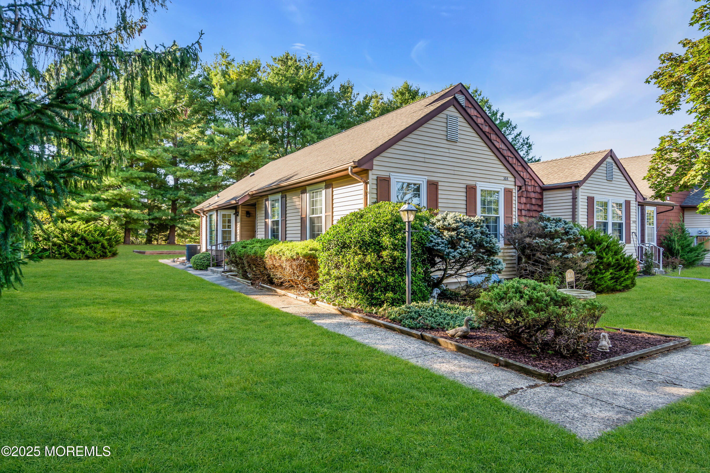 30 A Mill Road, Unit 64 Whiting, NJ 08759 - Photo 3 of 46 a front view of a house with a yard and potted plants