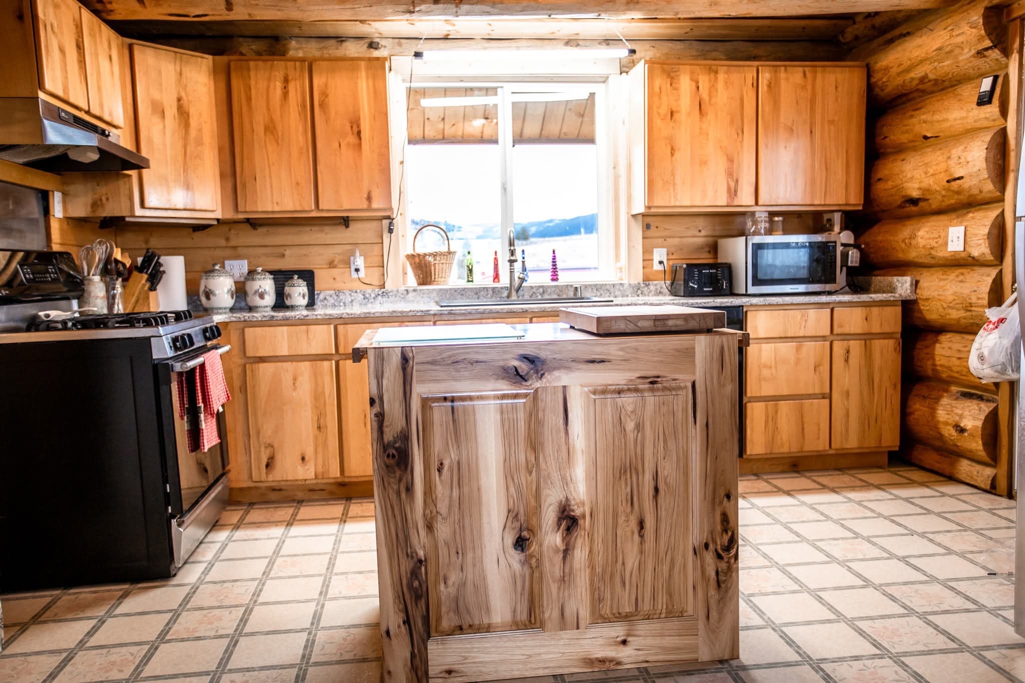 3358 Strandskov Road Lincoln, MT 59639 - Photo 6 of 80 Kitchen featuring rustic walls, sink, and stainless steel appliances