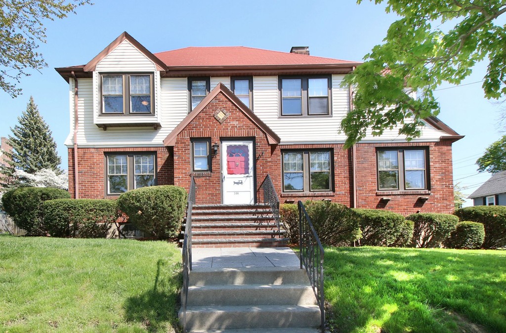 a front view of a house with a yard and porch