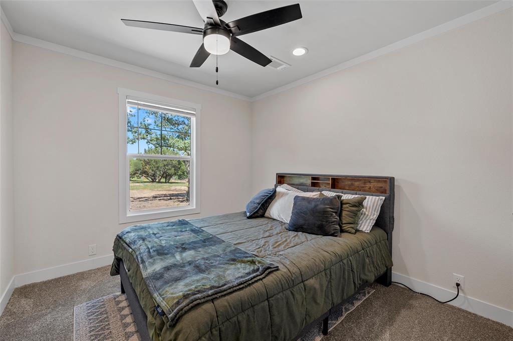 3050 Clater Powell Road Waco, TX 76705 - Photo 27 of 39 a bedroom with a large bed and a chandelier