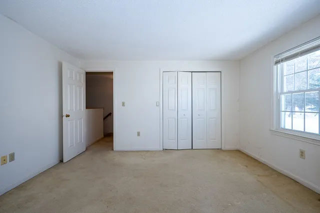 an empty room with windows and closet