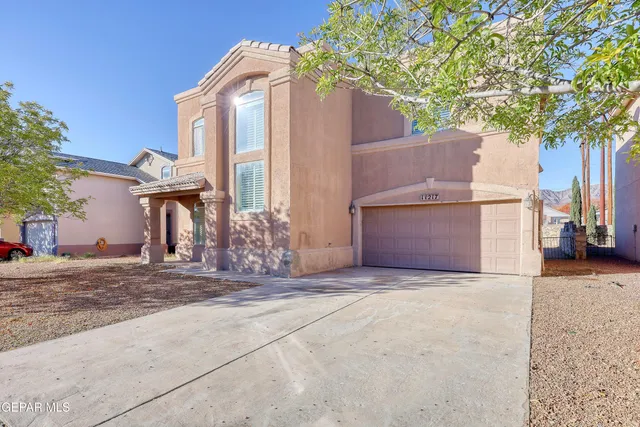 a front view of a house with a tree