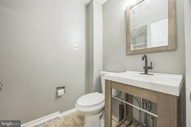 a bathroom with a sink a toilet and mirror