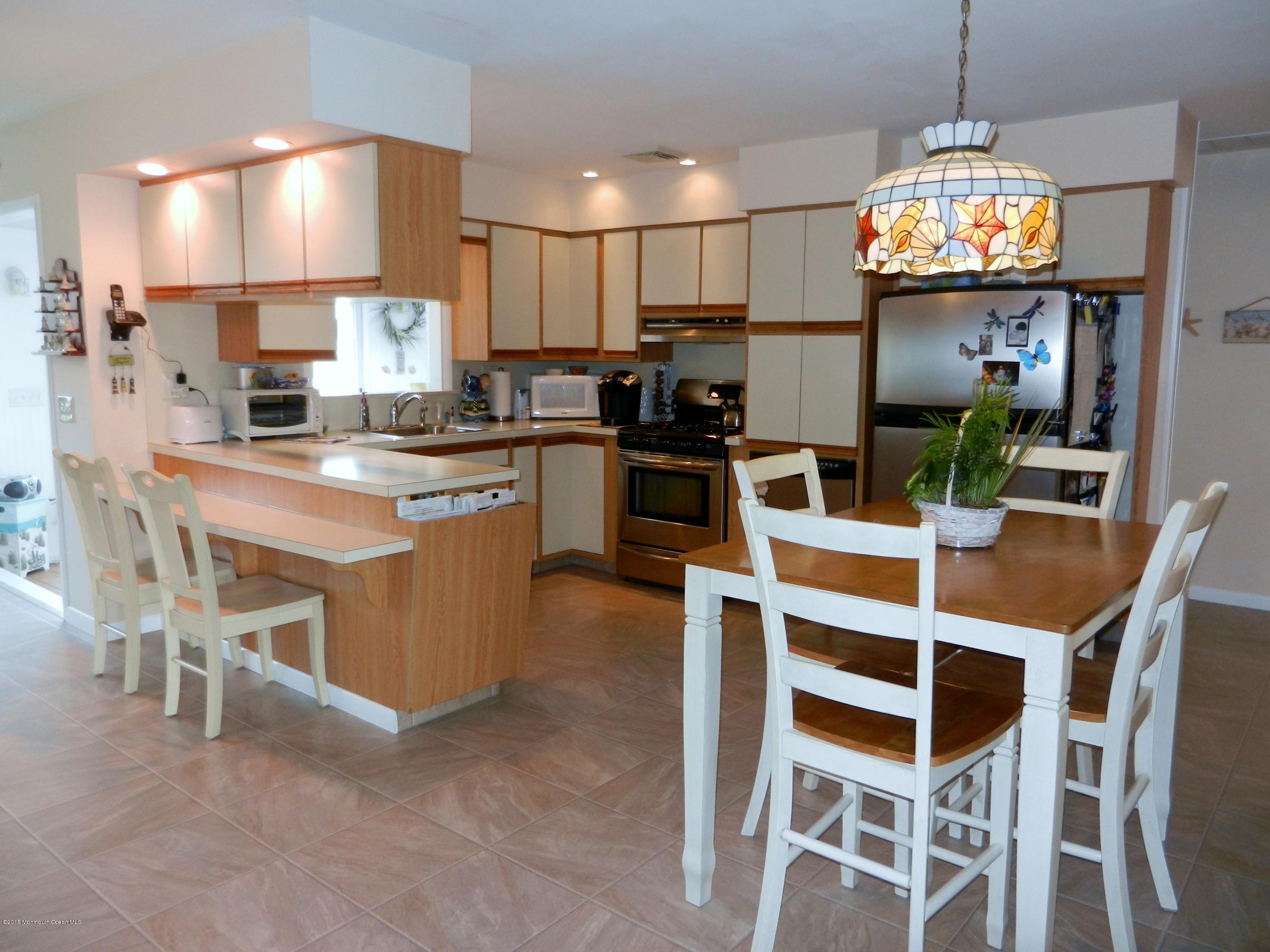 158 Cliff Road Brick, NJ 08724 - Photo 7 of 25 a kitchen with stainless steel appliances granite countertop a stove top oven a refrigerator a dining table and chairs
