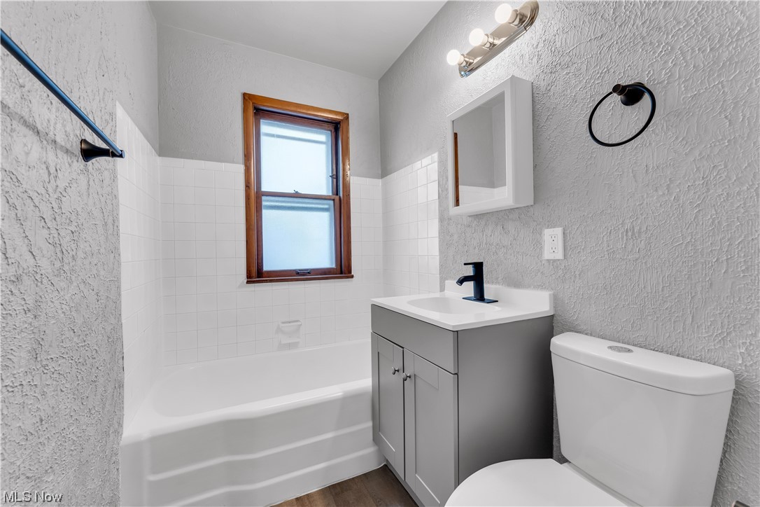 5384 Turney Road Cleveland, OH 44125 - Photo 17 of 27 Full bathroom with tiled shower / bath combo, toilet, vanity, and hardwood / wood-style flooring