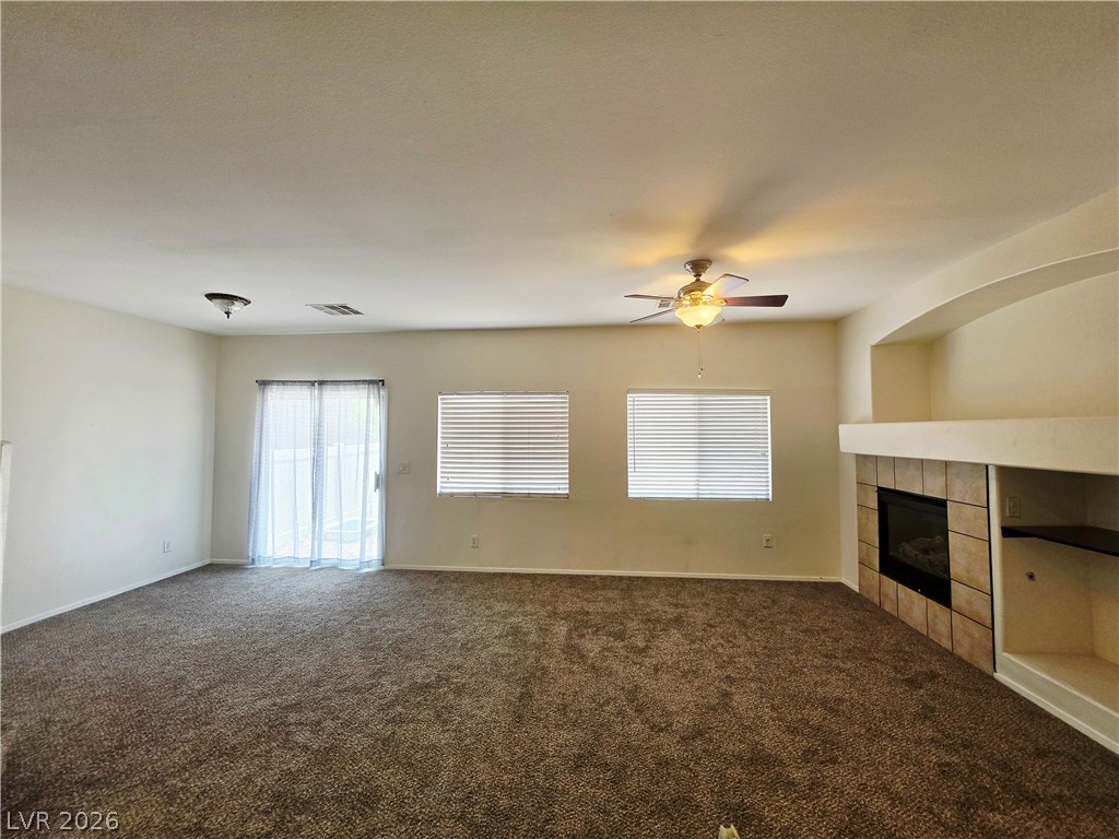 1571 Rusty Ridge Lane Henderson, NV 89002 - Photo 9 of 26 A spacious living area featuring plush carpeting and a warm, inviting fireplace.