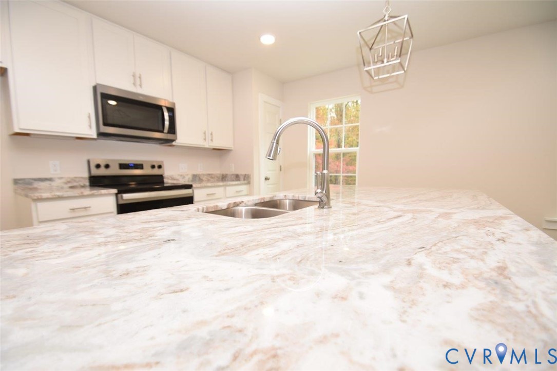 375 Amick Road Louisa, VA 23093 - Photo 7 of 25 a kitchen with granite countertop a stove and a white cabinets