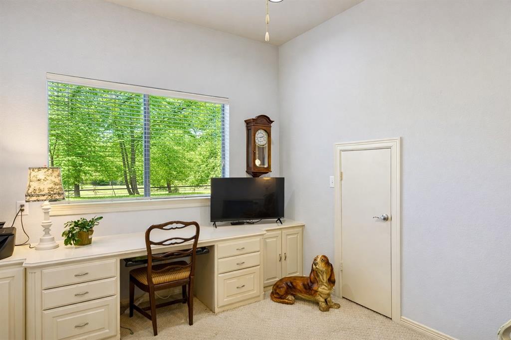 1520 Snider Court Lucas, TX 75002 - Photo 25 of 40 Dedicated home office with built-in desk and cabinetry, offering ample storage and a bright workspace with scenic outdoor views.