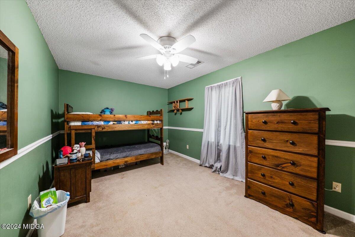 2559 Reedy Creek Road Forsyth, GA 31029 - Photo 13 of 20 a bedroom with furniture and a fan