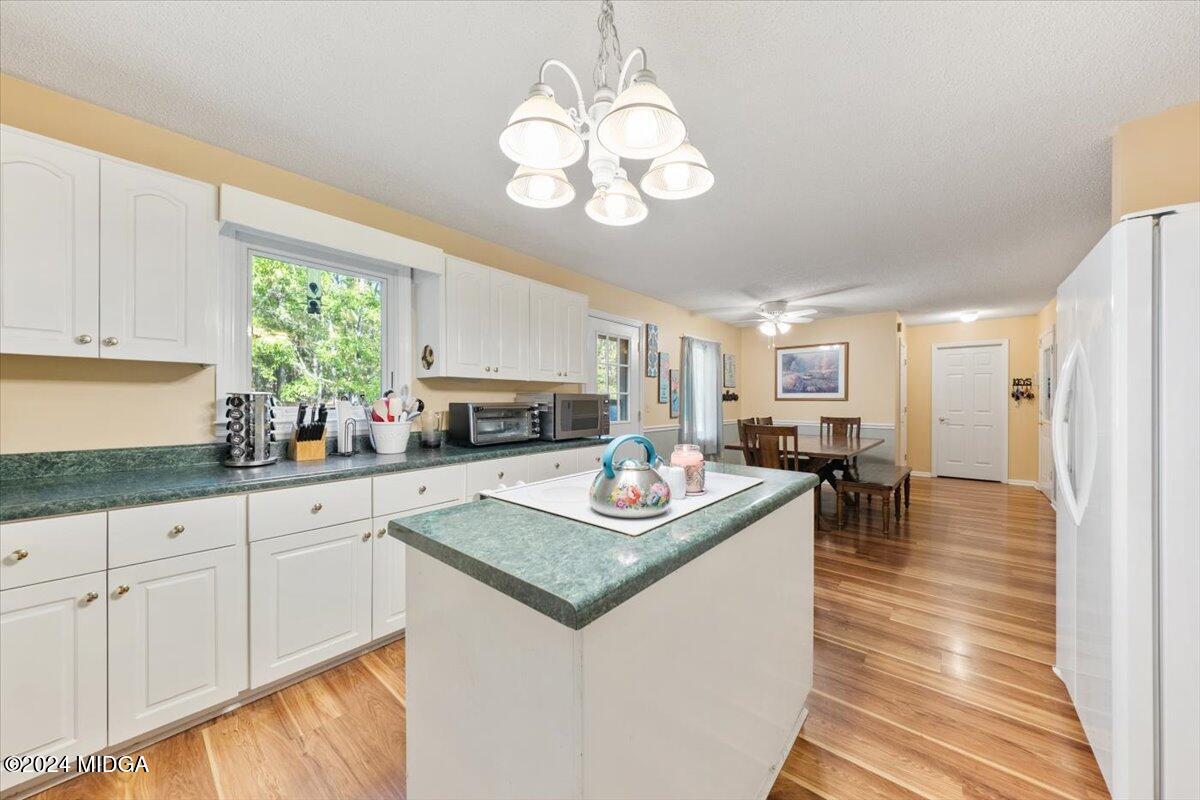 2559 Reedy Creek Road Forsyth, GA 31029 - Photo 5 of 20 a kitchen with stainless steel appliances granite countertop a stove top oven a sink dishwasher and white cabinets with wooden floor