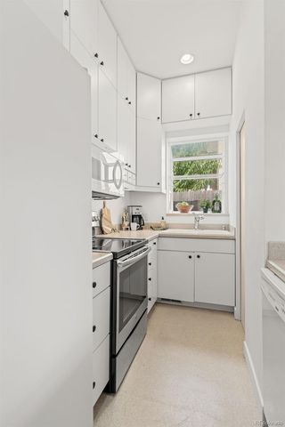 a kitchen with a sink cabinets stainless steel appliances and a window
