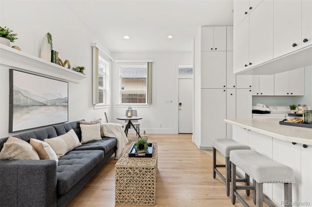 a living room with furniture and a painting on the wall
