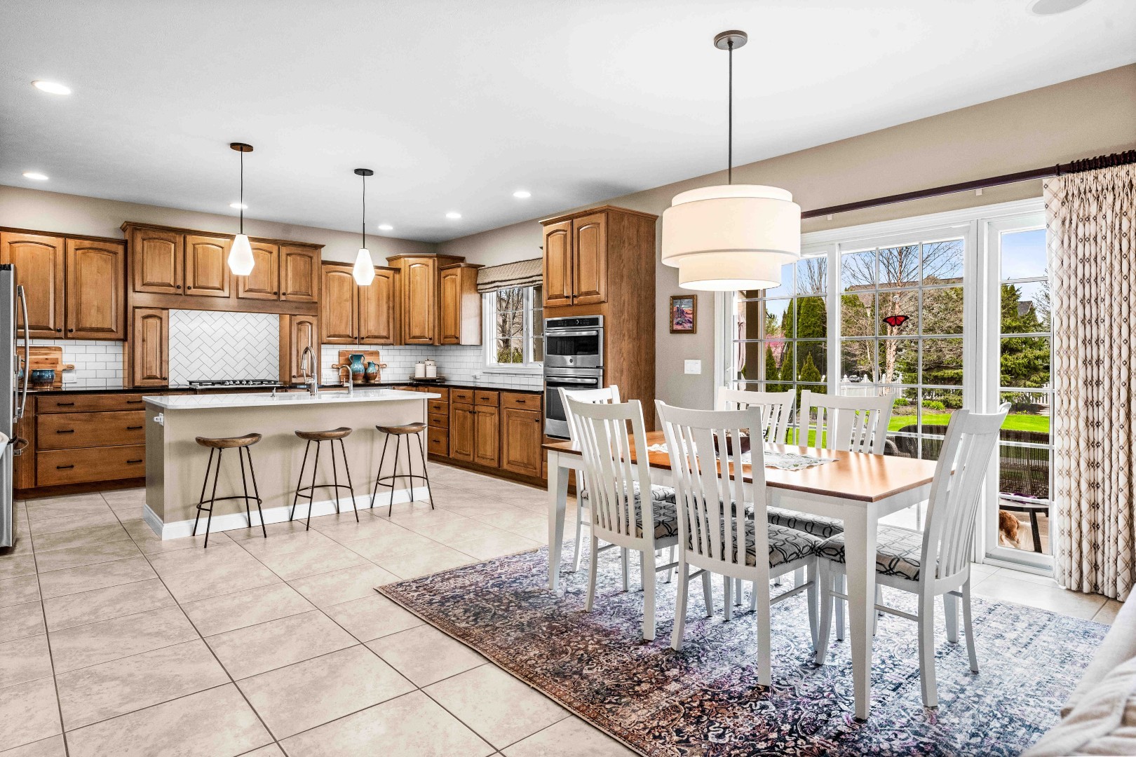 1048 Norway Court Normal, IL 61761 - Photo 18 of 83 a dining hall with stainless steel appliances granite countertop a stove a kitchen island a table and chairs