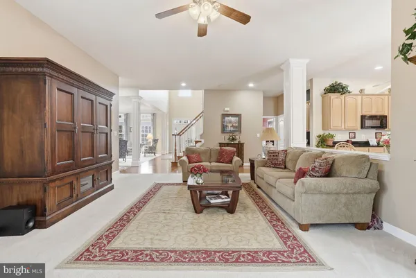 a kitchen with stainless steel appliances kitchen island granite countertop a refrigerator a stove a microwave oven a dining table and chairs with wooden floor