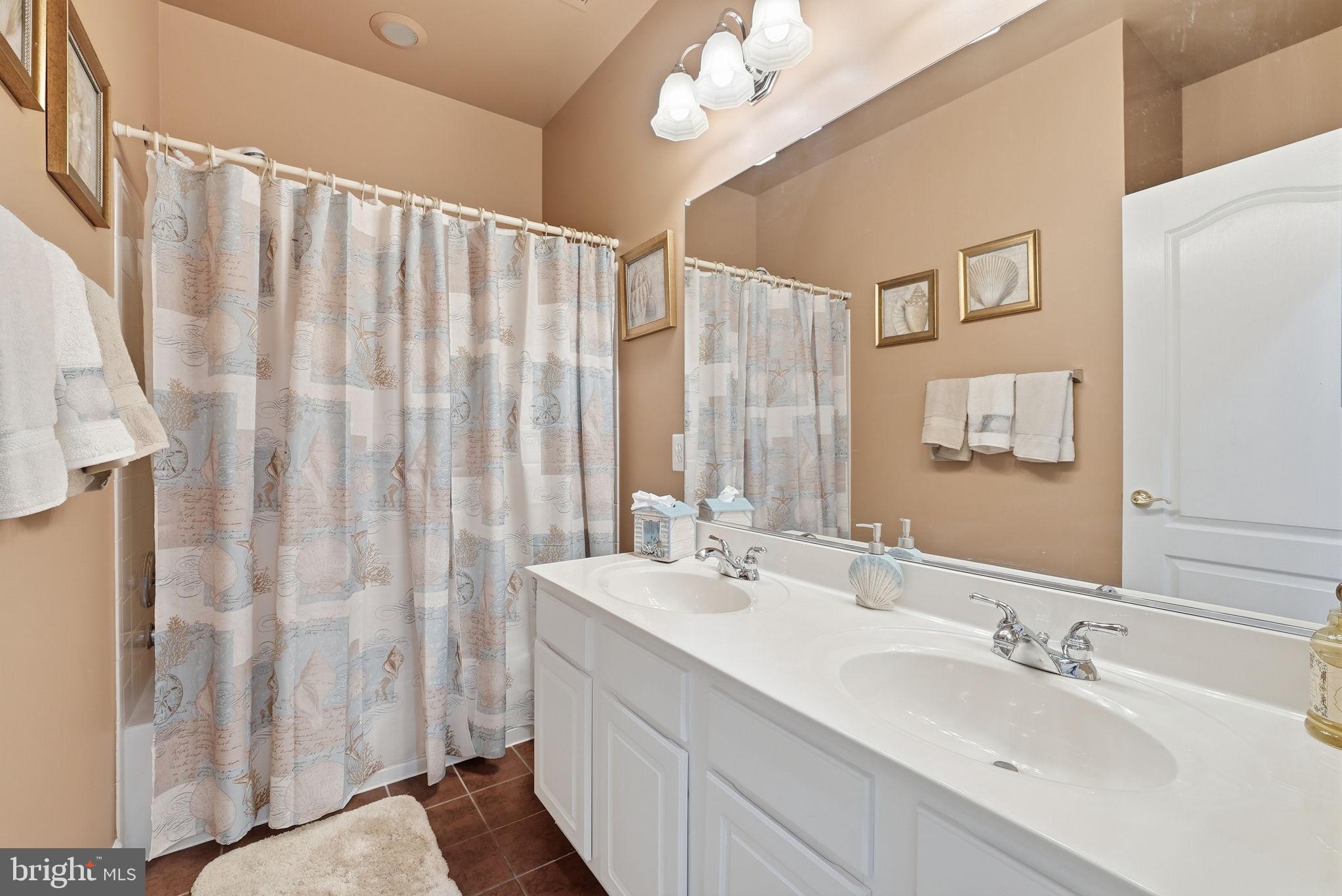 7820 Rose Garden Lane Springfield, VA 22153 - Photo 30 of 65 a bathroom with double vanity sinks a mirror a shower and a large mirror