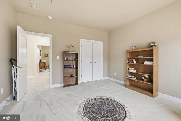 a spacious bedroom with a large bed and a chandelier