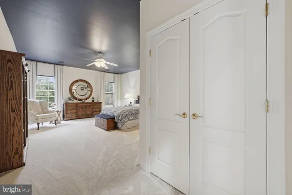 a spacious bedroom with a large bed and a chandelier