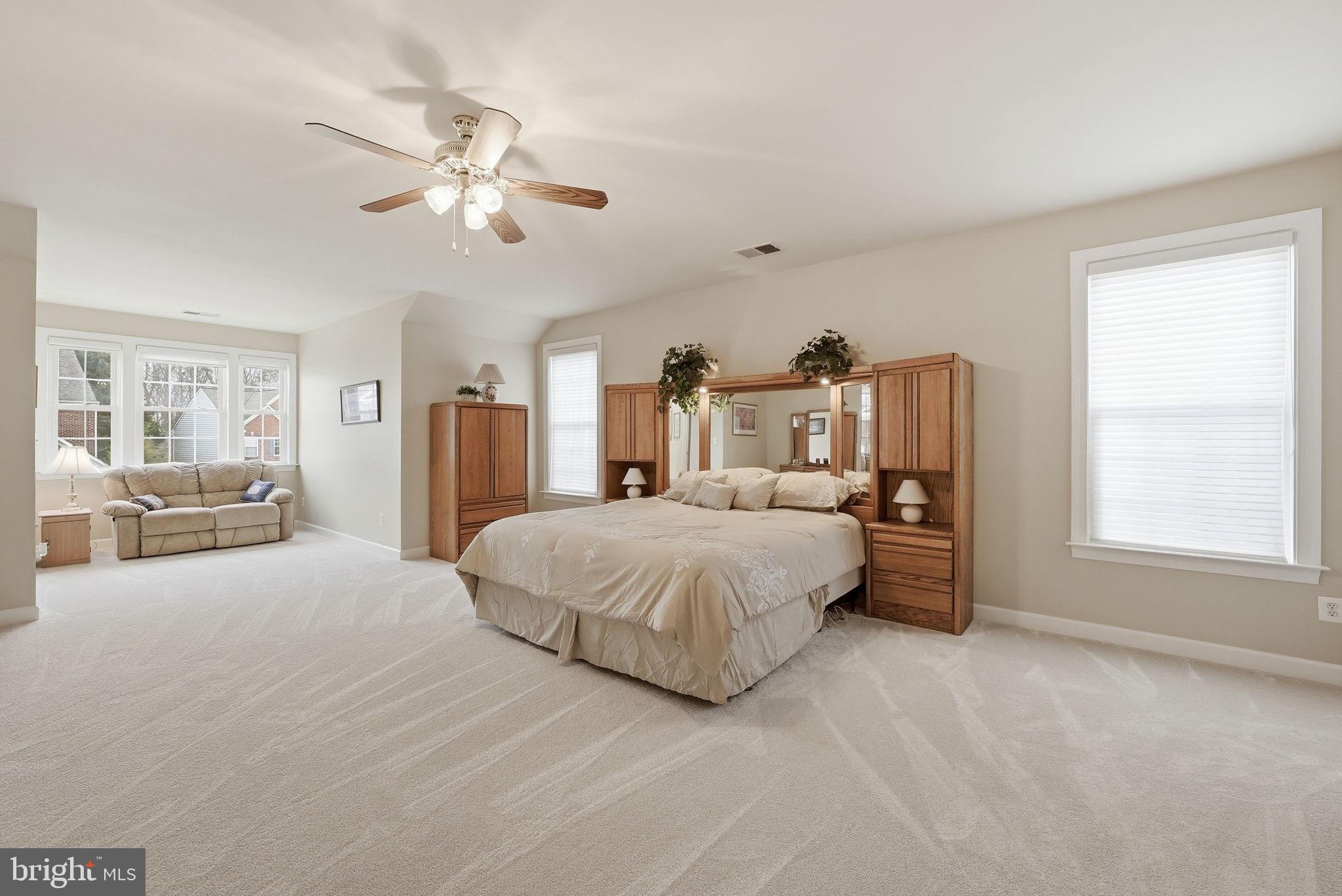 7820 Rose Garden Lane Springfield, VA 22153 - Photo 44 of 65 a spacious bedroom with a large bed and a chandelier