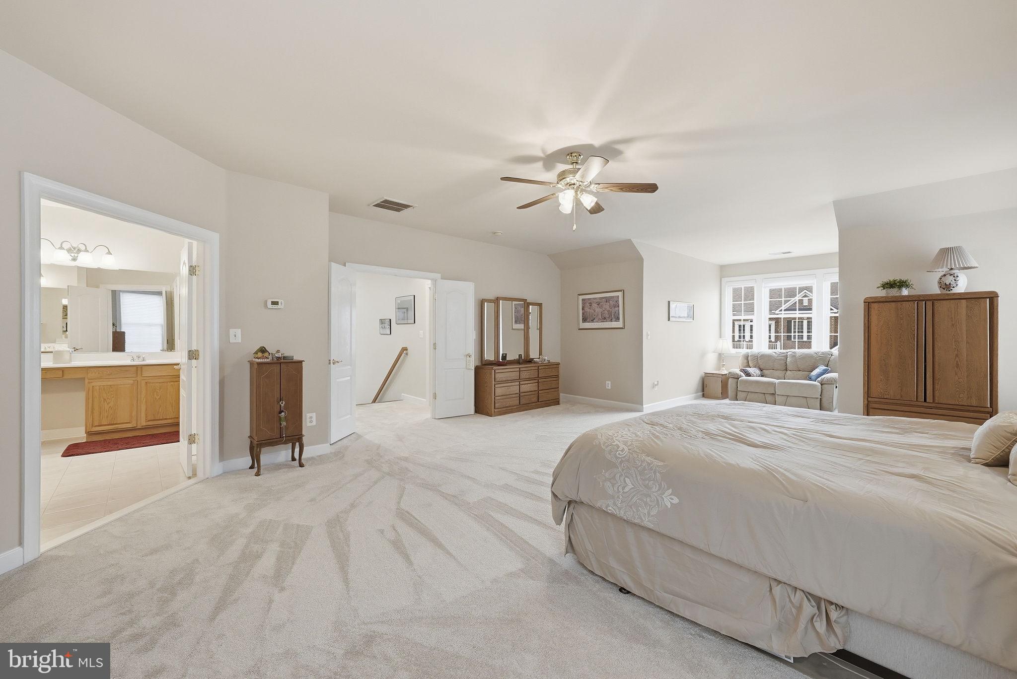 7820 Rose Garden Lane Springfield, VA 22153 - Photo 45 of 65 a spacious bedroom with a large bed and a chandelier