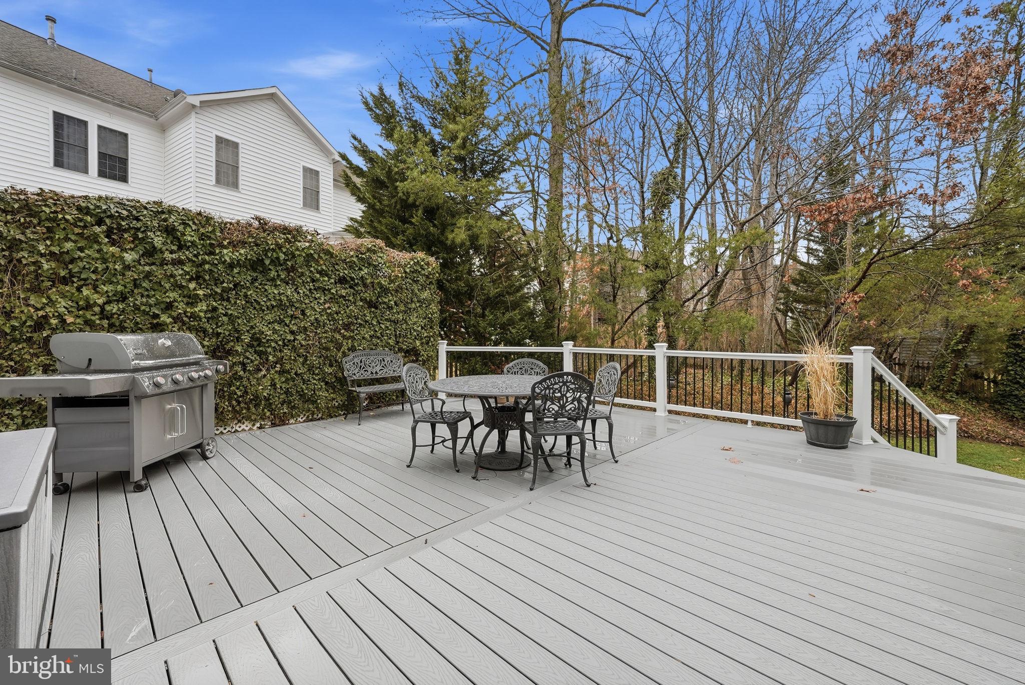 7820 Rose Garden Lane Springfield, VA 22153 - Photo 56 of 65 a view of a roof deck with table and chairs a barbeque with wooden floor and fence