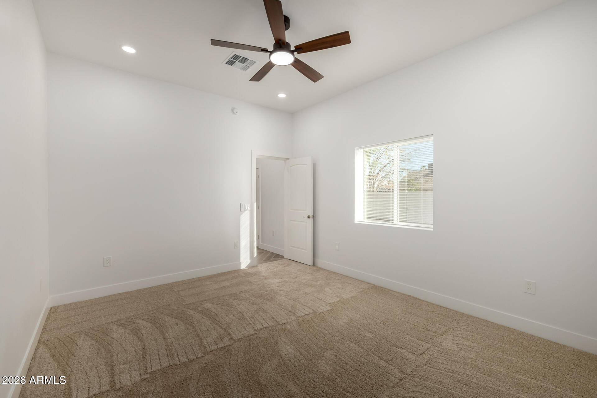 6345 West Grandview Road Glendale, AZ 85306 - Photo 31 of 36 an empty room with a window and a fan