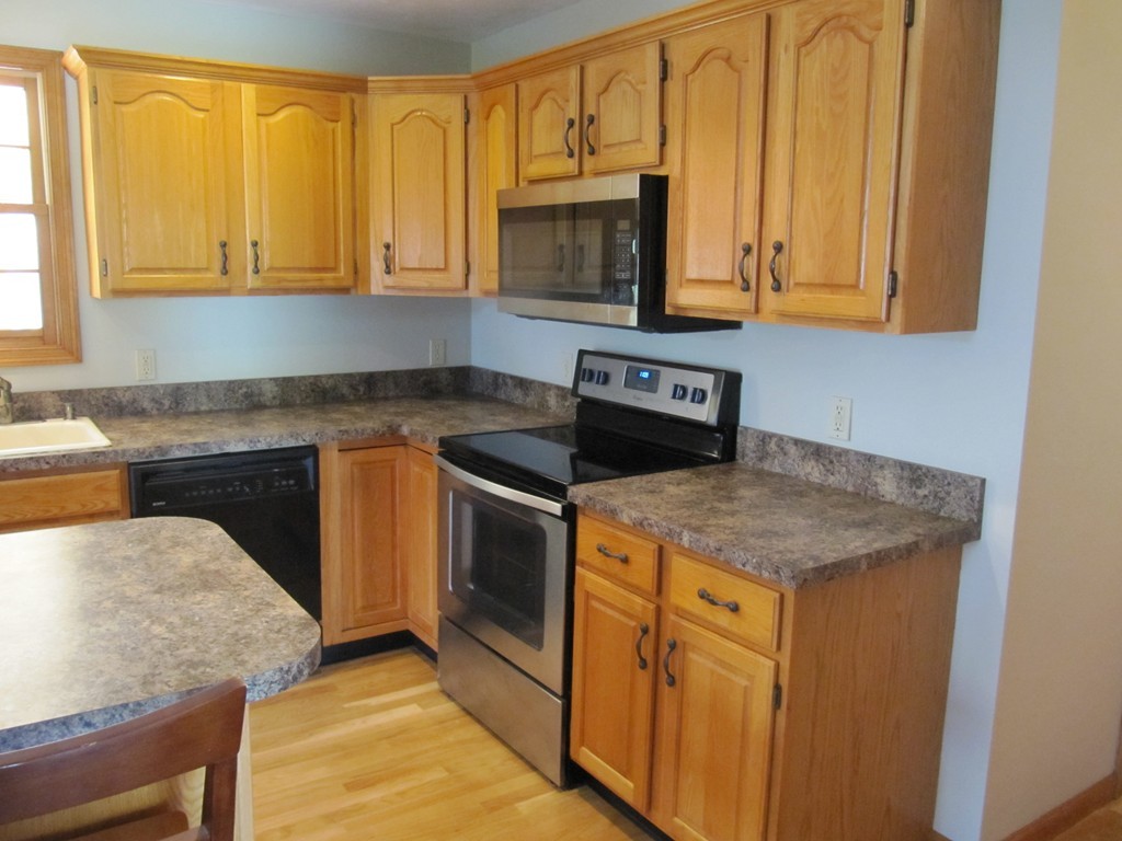 88 McClellan Road Sutton, MA 01590 - Photo 12 of 30 a kitchen with stainless steel appliances granite countertop a stove a sink and a microwave
