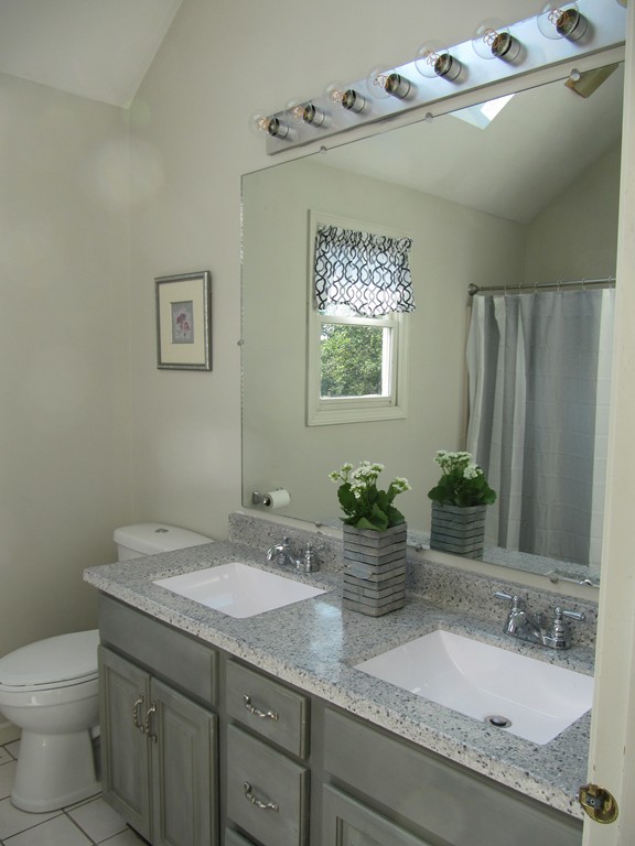 88 McClellan Road Sutton, MA 01590 - Photo 27 of 30 a bathroom with a granite countertop sink a toilet and a mirror