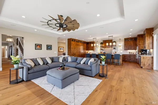 a living room with furniture a fireplace and a dining table with kitchen view