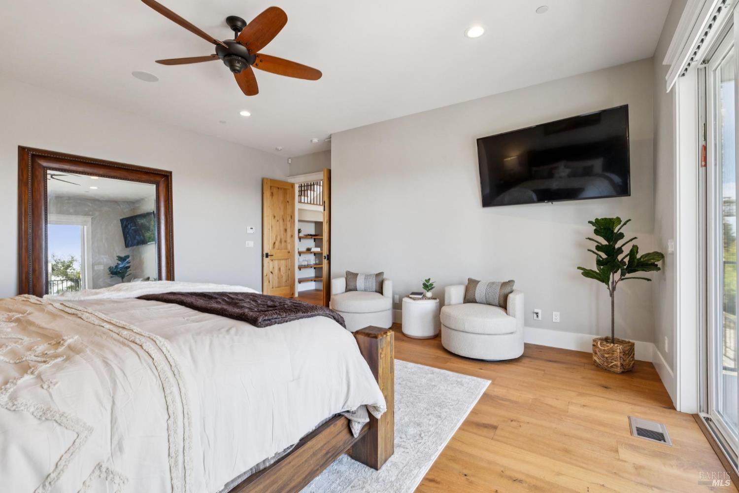 3882 Royal Manor Place Santa Rosa, CA 95404 - Photo 39 of 87 Spacious Main Level Primary Suite with balcony overlooking the city of Santa Rosa and the Sonoma Mountains. This suite features, hardwood floors, surround sound, recessed lighting, ceiling fan, dual sinks, walk in shower with dual shower heads, large jetted soaking tub, walk-in closet large doorways and openings for accessibility and more.