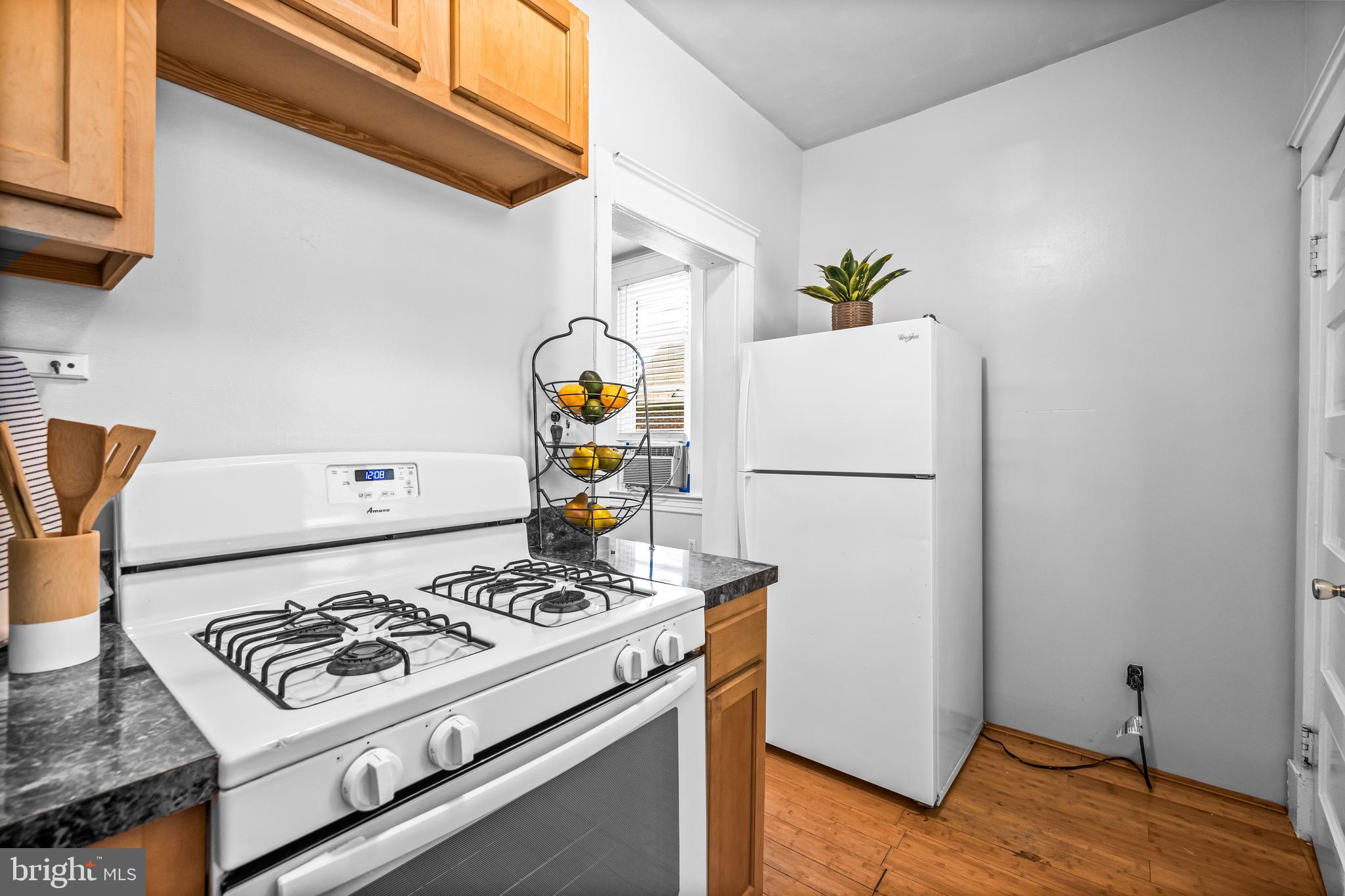 4406 Mainfield Avenue Baltimore, MD 21214 - Photo 15 of 47 a white refrigerator freezer and a wooden floor