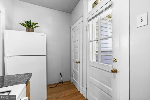 a white refrigerator freezer and a dishwasher with wooden floor