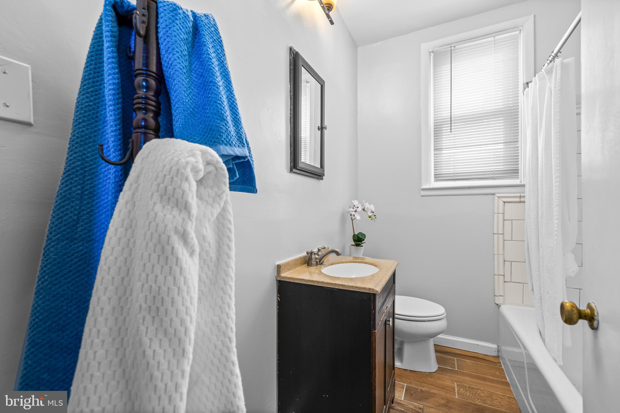 4406 Mainfield Avenue Baltimore, MD 21214 - Photo 24 of 47 a white toilet sitting next to a bathroom sink and vanity