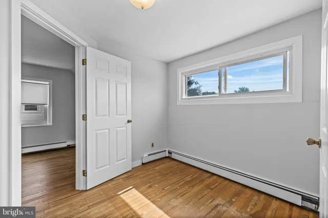 a view of empty room with wooden floor