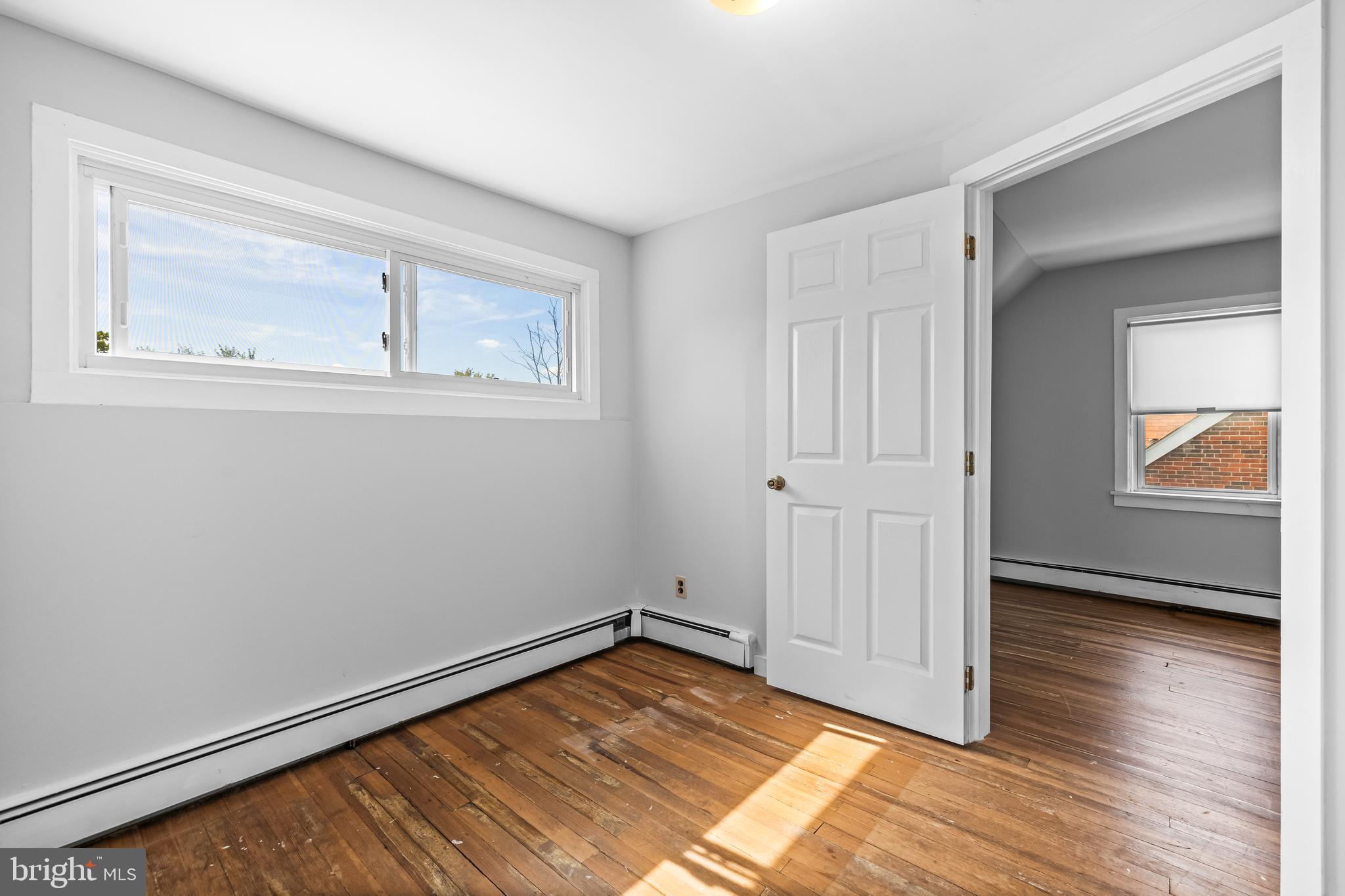 4406 Mainfield Avenue Baltimore, MD 21214 - Photo 27 of 47 a view of an empty room with wooden floor and a window