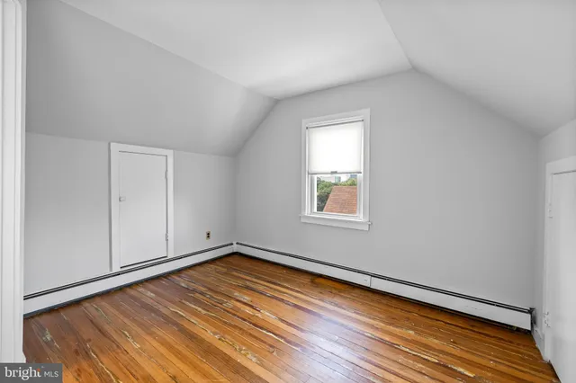 a view of a room with wooden floor and white walls