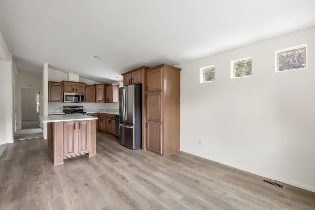 a kitchen with refrigerator cabinets and wooden floor
