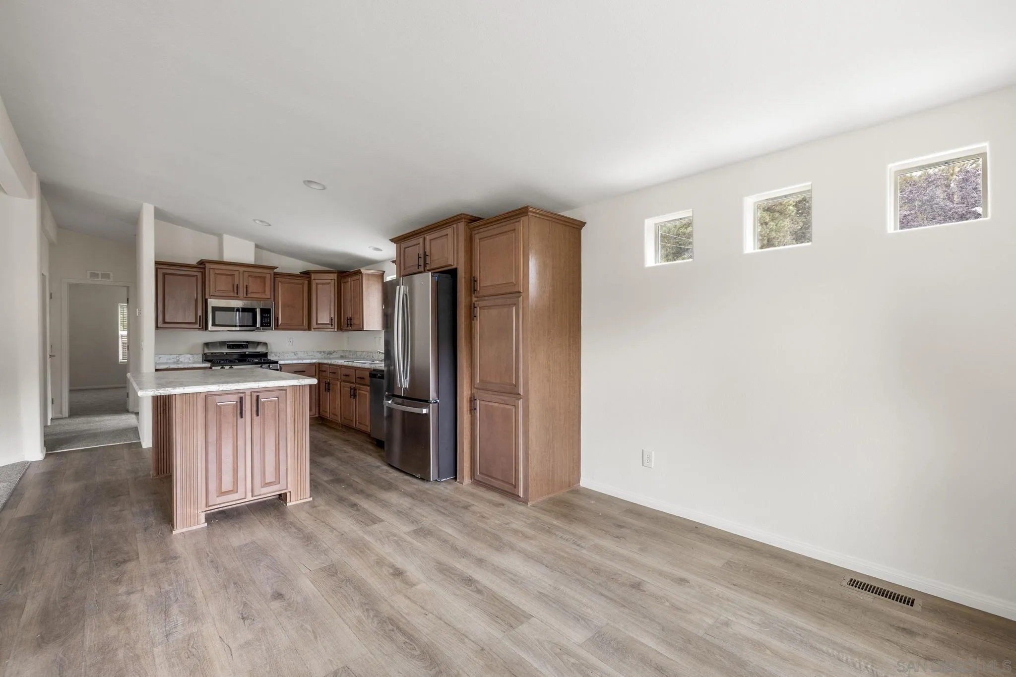 22899 Byron Road, Unit 11 Crestline, CA 92325 - Photo 13 of 25 a kitchen with refrigerator cabinets and wooden floor