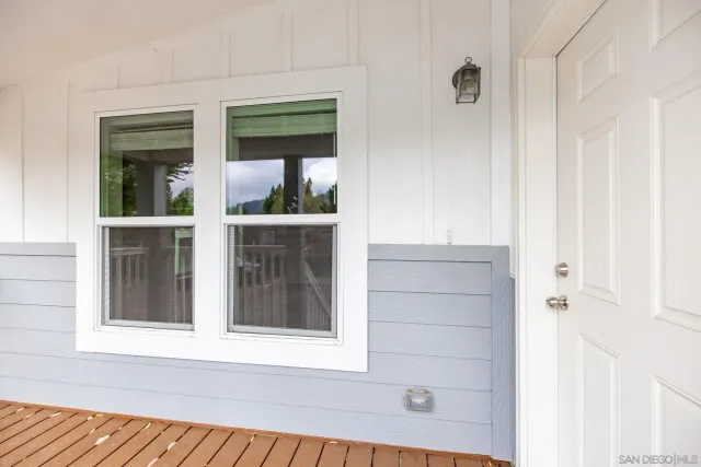 a view of a hallway with wooden floor and a bathroom