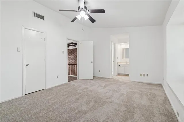 an empty room with closet and windows