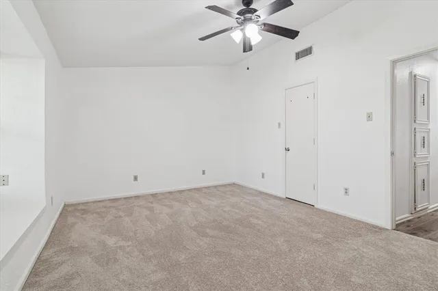 an empty room with a fan and a fan
