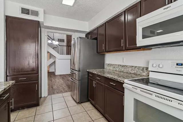a kitchen with granite countertop a refrigerator and a stove