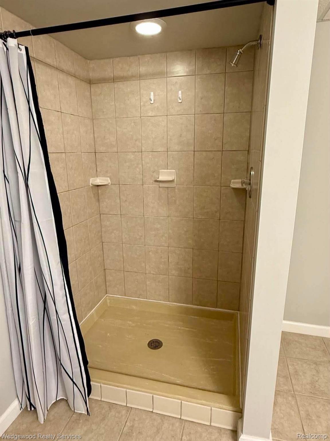 492 Harvard Drive, Unit 84 Romeo, MI 48065 - Photo 21 of 30 Tiled shower with a built-in shelf, recessed lighting, and a showerhead with a single handle control