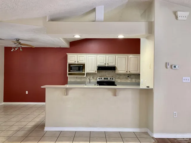 a large kitchen with stainless steel appliances a refrigerator and a stove top oven